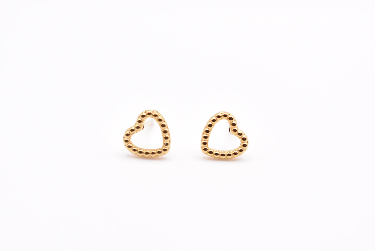 Gold minimalist heart earrings on white background