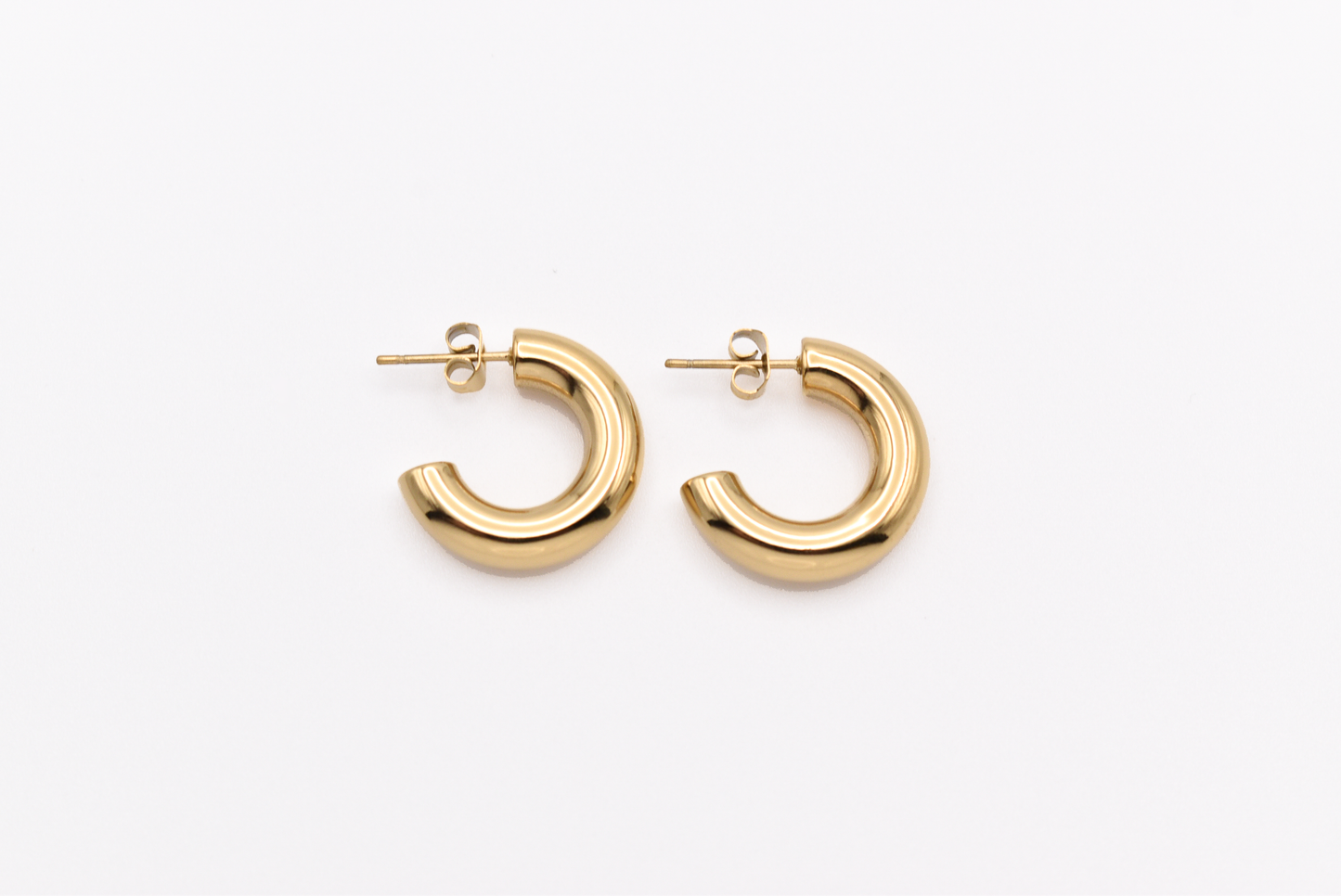 Chunky gold hoop earrings on white background