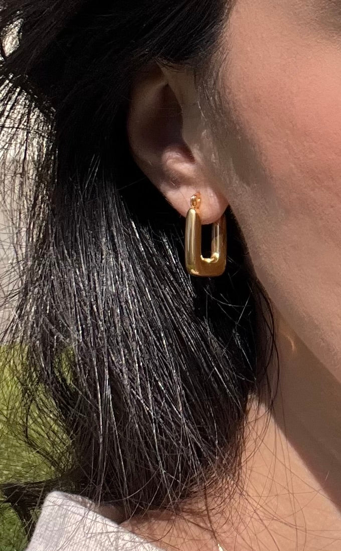 Titanium gold plated hoop earrings styled on model outdoors