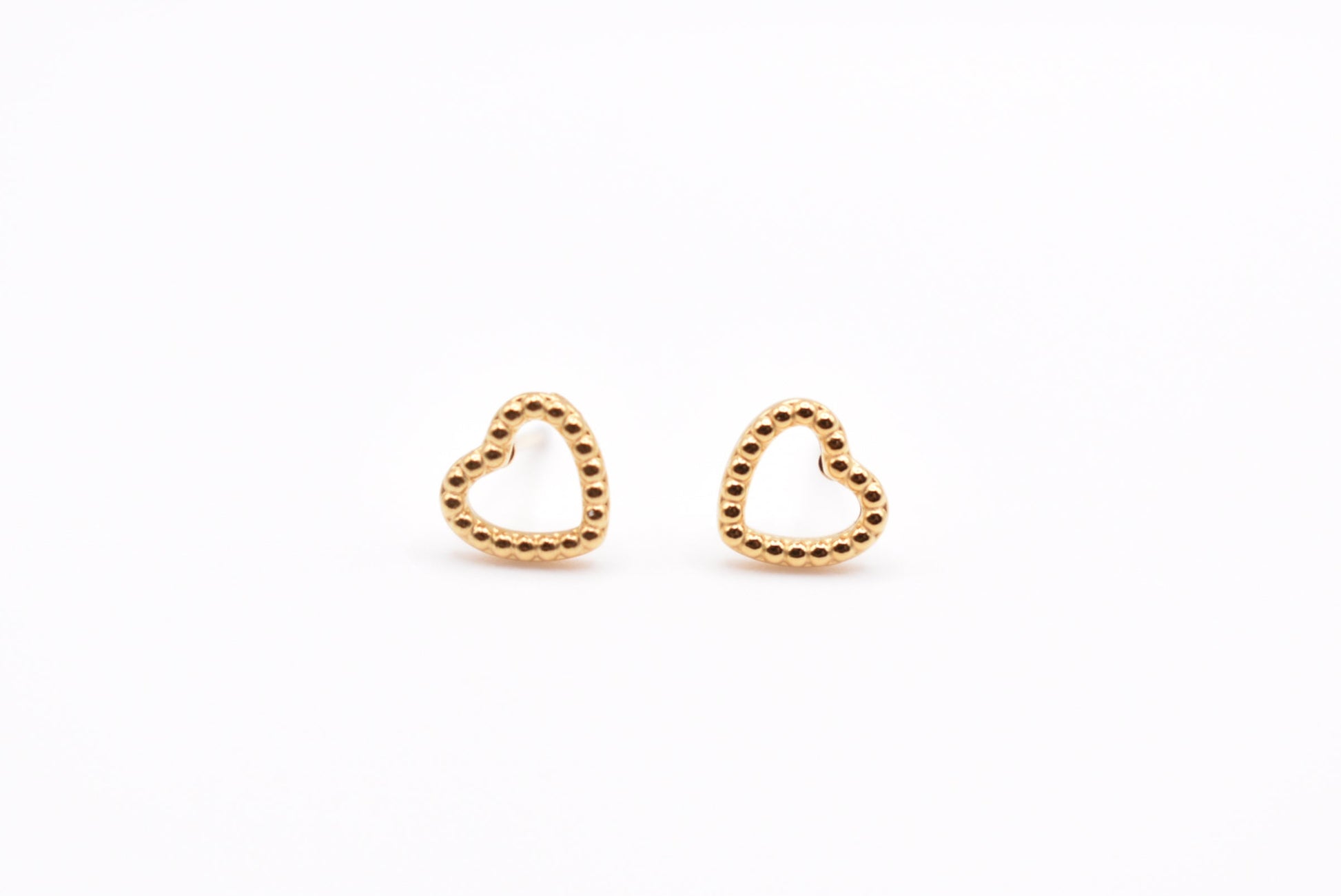 Gold minimalist heart earrings on white background

