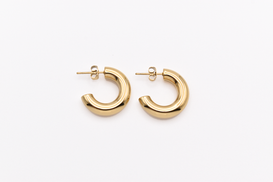 Chunky gold hoop earrings on white background