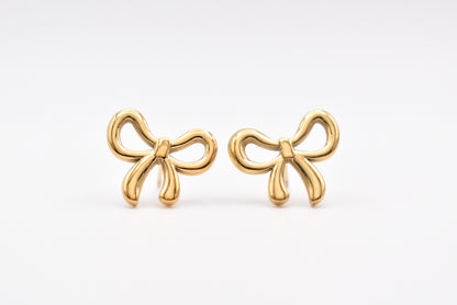 Gold bow-shaped stud earrings on white background