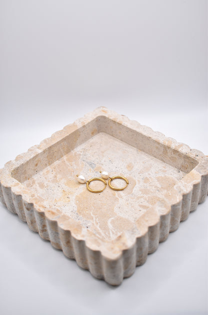 Gold hoops with pearl drops styled in jewelry tray